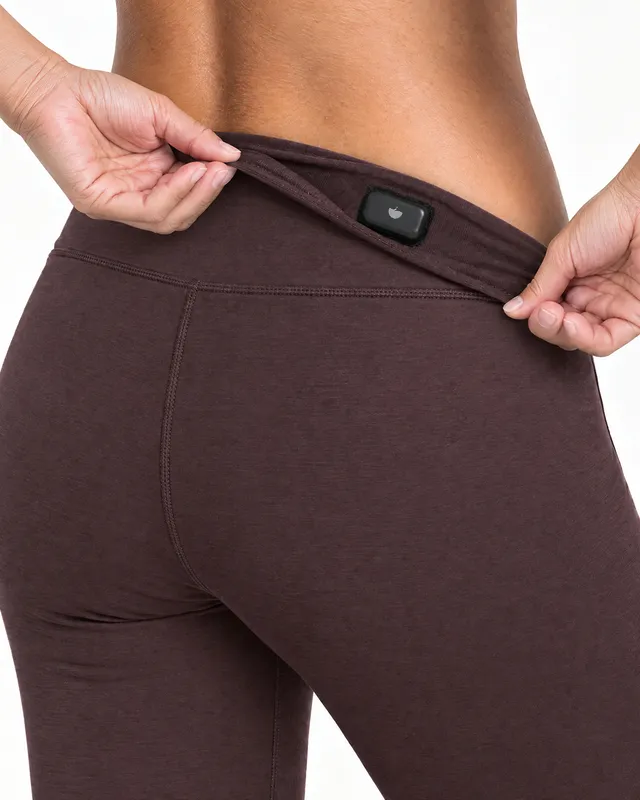 Close-up of the discreet waistband pocket on the Ardra legging, holding a health device